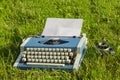 Typewriter and old camera in the grass